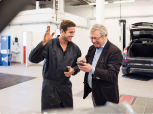 Mekaniker og kunde inne på bilverkstedet