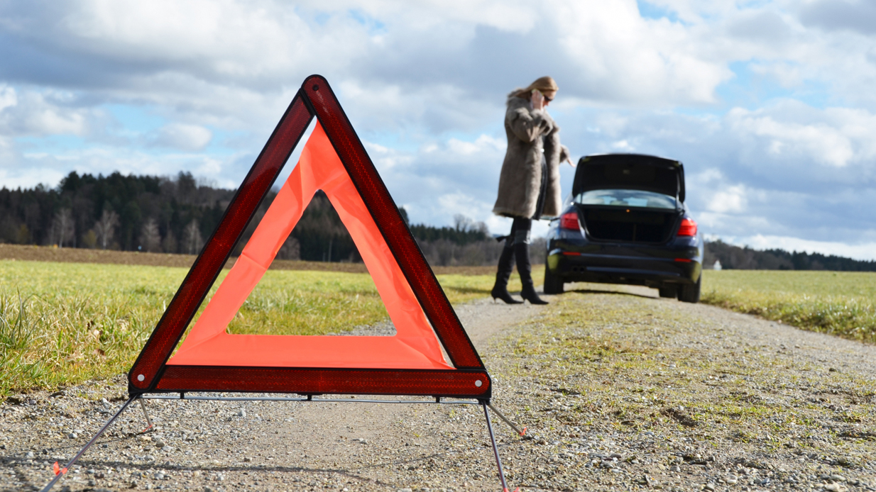 Dame har fått motorstopp på bilen og satt ut varseltrekant før hun ringer etter assistanse