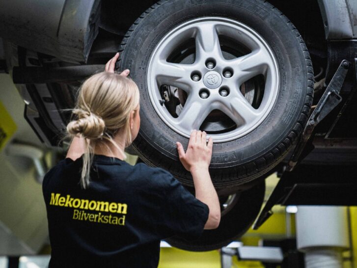 Kvinnelig mekanikes hos Mekonomen skifter dekk på bilen