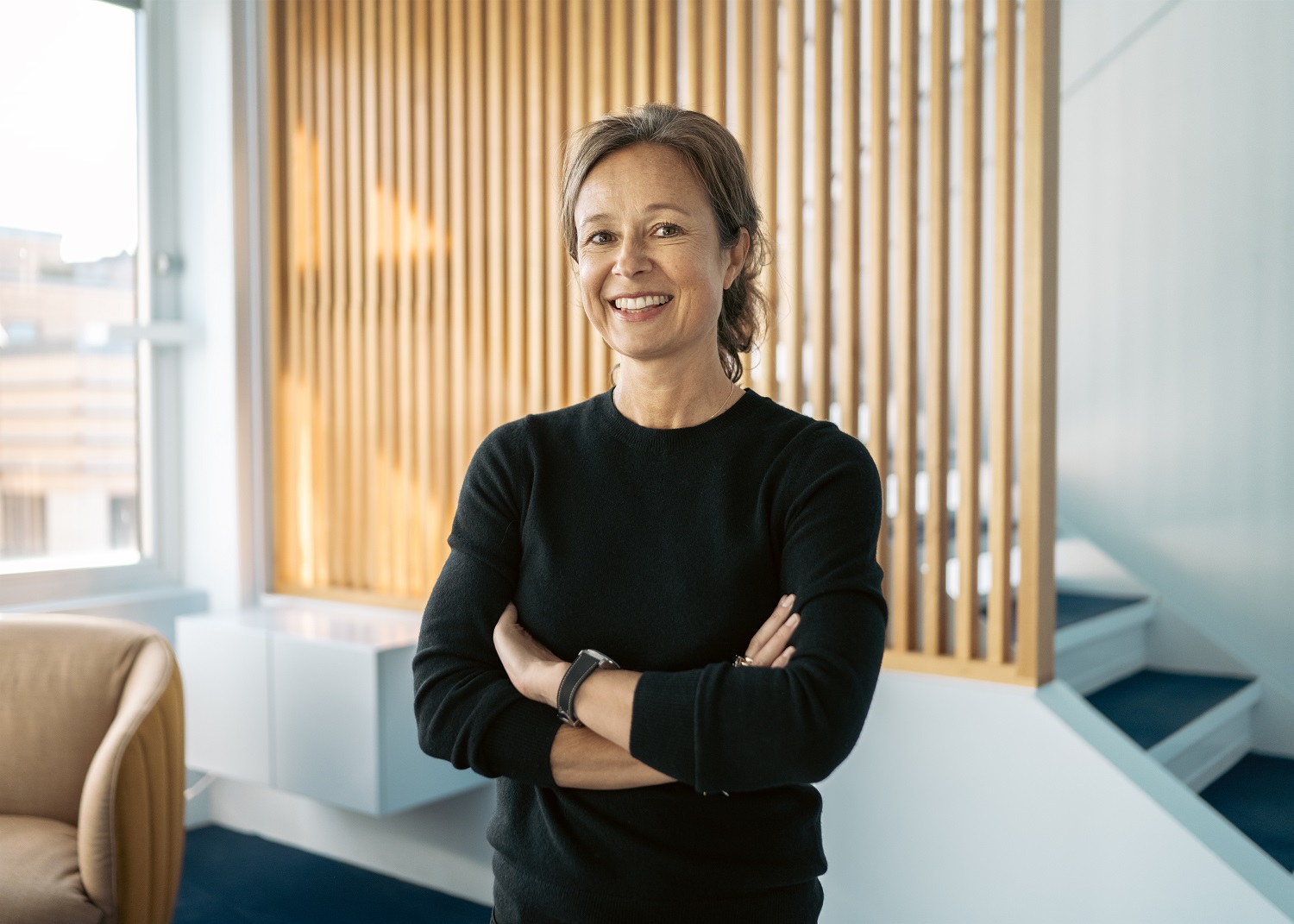 Dame i sort genser foran en spilevegg i eik